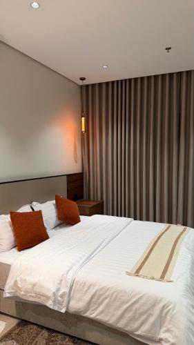 ein Schlafzimmer mit einem großen Bett mit weißer Bettwäsche in der Unterkunft هاوس تو 21 in Abha