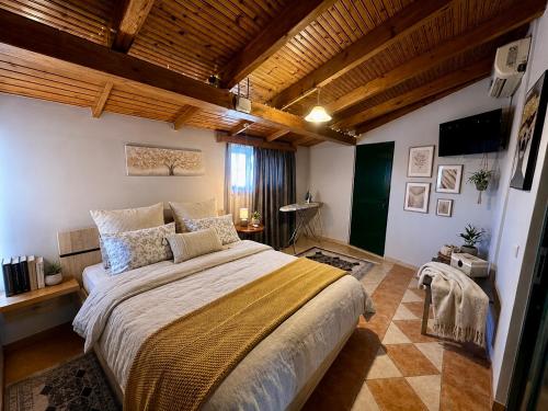 a bedroom with a large bed in a room with wooden ceilings at Bratis House in Vartholomio