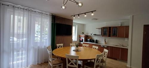 a kitchen and dining room with a table and chairs at Apartament Piastowska in Ostróda