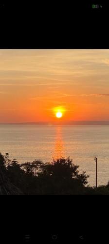 a sunset over the ocean with the sun in the sky at Sky Beach Resort Ltd in Kisumu