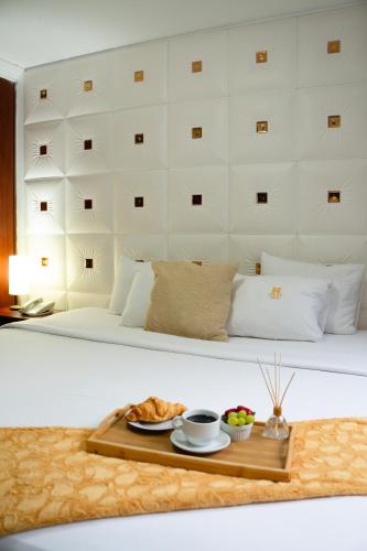 a bed with a tray of food on it at Inkari Apart Hotel in Lima