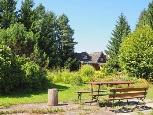 a picnic table and a bench in a park at Pensjonat i domki Kresy in Pogorzelce