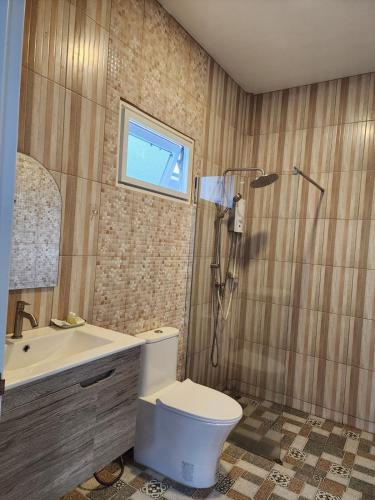 a bathroom with a toilet and a sink and a shower at Chomlay House in Ban Thepha