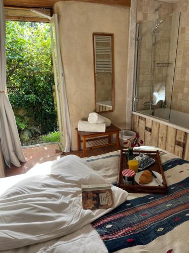 a bedroom with a bed with a tray of food on it at Pathways, Beachwood Cottage in Bath