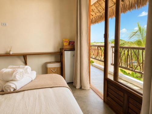 a bedroom with a bed with a view of a balcony at The Wave Kite House in Guriú