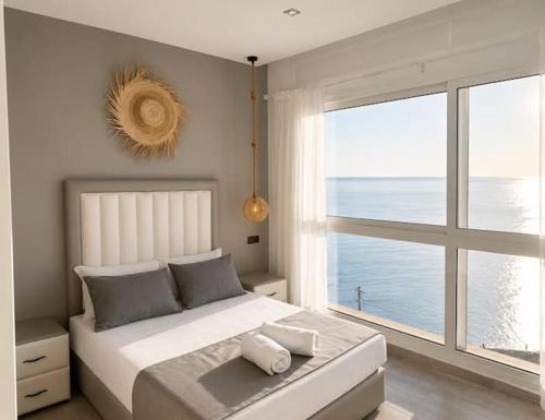 a bedroom with a large bed and a large window at Sensia Mediterranean Escape in Aouchtame