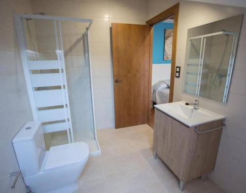 a bathroom with a toilet and a sink and a shower at La Casona De Cuellar in Cuéllar