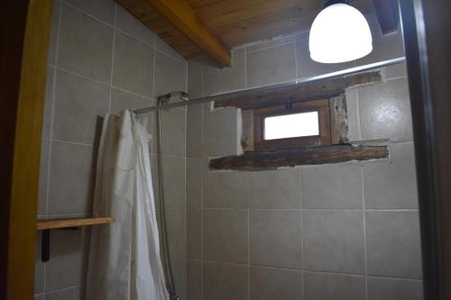 a bathroom with a shower with a curtain and a window at Camping El Paraíso in El Hoyo
