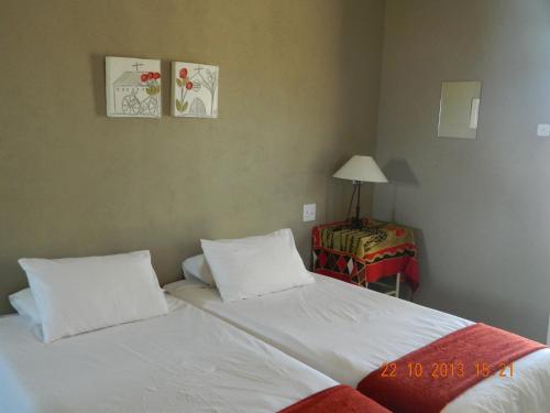 a bedroom with two beds and a table with a lamp at Vastrap Guest Farm in Grünau
