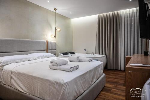 a bedroom with a bed with towels on it at Rubin Boutique in Korçë