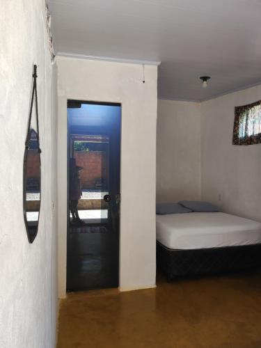a room with a bedroom with a bed and a door at Cantinho da Lobeira in Alto Paraíso de Goiás