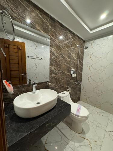a bathroom with a sink and a toilet at Holiday One Hotel & Suites - Gulshan-4 in Karachi