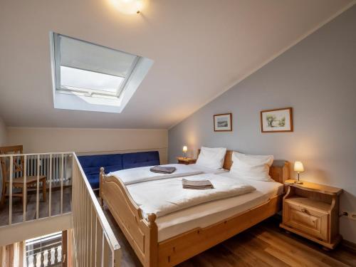 a bedroom with a large bed with a skylight at Bergschlössl - Massionettwohnung 22 in Oberaudorf