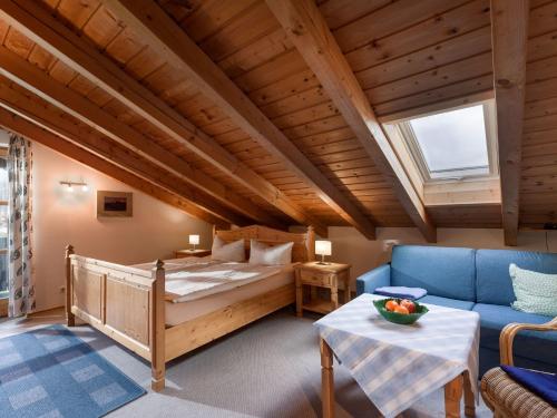 a bedroom with a bed and a couch and a table at Mit einem Traumblick App 37 in Oberaudorf