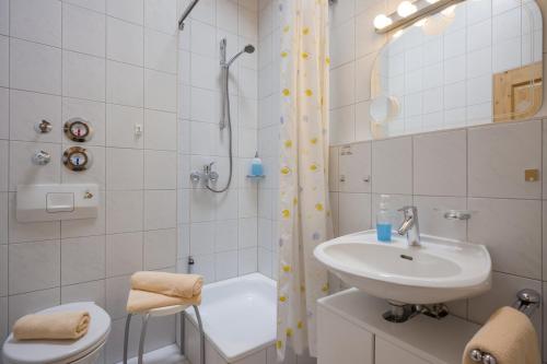 a white bathroom with a sink and a shower at Mit einem Traumblick App 37 in Oberaudorf