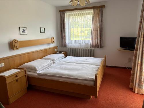 ein Schlafzimmer mit einem großen Bett und einem Fenster in der Unterkunft Rupertihof in Fuschl am See