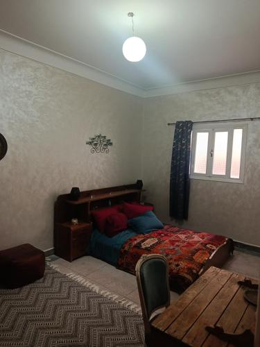 a bedroom with a bed and a table in it at Dar Cadi in Safi