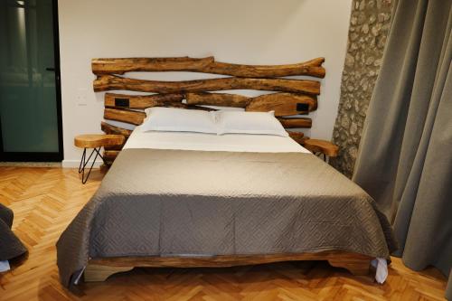 a bed in a room with a wooden wall at Albulena Hotel & Camping in Shkodër