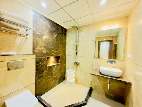 a bathroom with a sink and a toilet and a shower at Hotel Sanidhyam Bliss in Varanasi