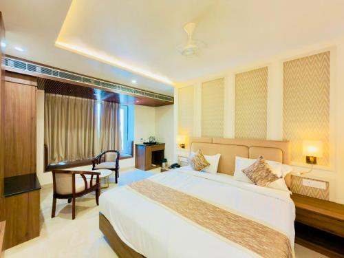 a hotel room with a bed and a desk and a desk at Hotel Sanidhyam Bliss in Varanasi
