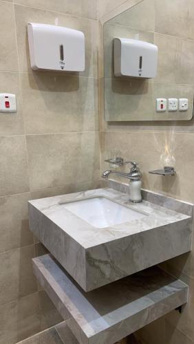 a bathroom with a marble sink and a mirror at فندق أوريون orion hotel in Al-ʿUla
