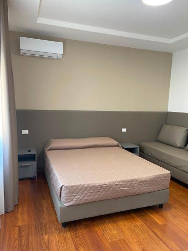 a small bedroom with a bed and a couch at B&B Casa Claudio in San Giovanni Rotondo