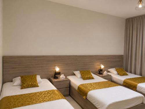 a hotel room with two beds and two lamps at فيلا وشاليه الجبل الاحمر in Al-ʿUla