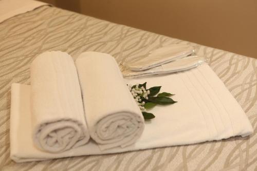 a couple of white towels on a bed at Mariano Suites in Stigliano