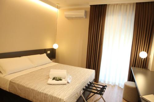 a bedroom with a bed with two towels on it at Mariano Suites in Stigliano