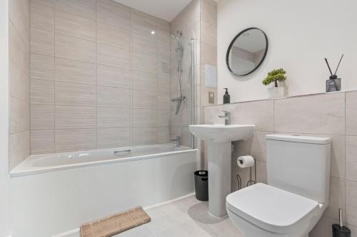 a bathroom with a toilet and a tub and a sink at Thameside Suite | Free Parking | 2 BR | Heathrow in Staines