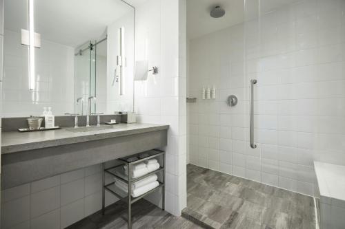 a white bathroom with a sink and a shower at Archer Hotel Old Town Alexandria in Alexandria