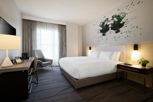 a hotel room with a large bed and a desk at Archer Hotel Old Town Alexandria in Alexandria