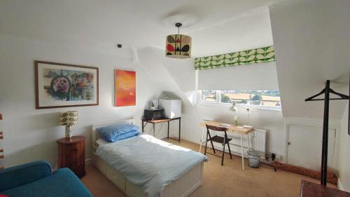 a bedroom with a bed and a desk and a window at 15 Aller Park Rd, Newton Abbot in Newton Abbot