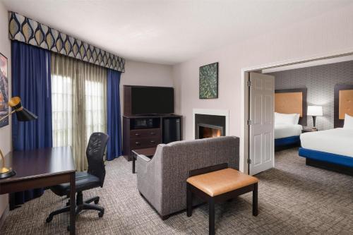 a hotel room with a bedroom with a bed and a desk at Best Western Plus Grant Creek Inn in Missoula