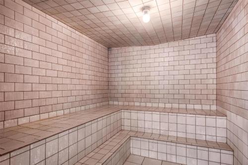 a white tiled bathroom with white tiles on the wall at Best Western Plus Grant Creek Inn in Missoula