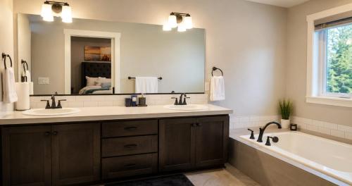 a bathroom with two sinks and a tub and a mirror at Kwem Homes in Salem
