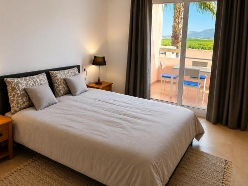 a bedroom with a bed with a view of a patio at Condado de Alhama - Suchan living in El Romero