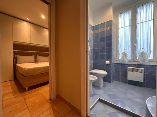 a bathroom with a toilet and a bed in a room at HENRY BENNEt in Menton