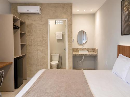a hotel room with a bed and a bathroom at Exclusive Hotel in Campos Sales