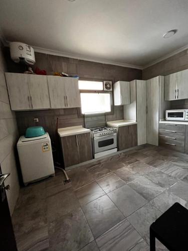 a small kitchen with white cabinets and a refrigerator at شقة مخدومة 101 in Medina