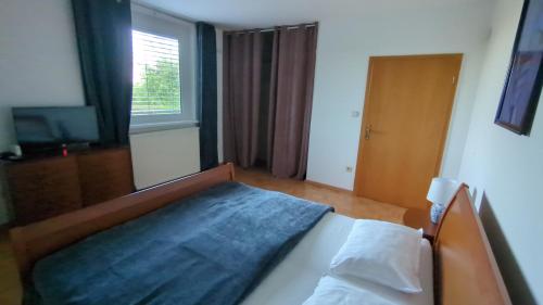 a bedroom with a bed with a blue blanket on it at Apartma pri Boru in Ptuj