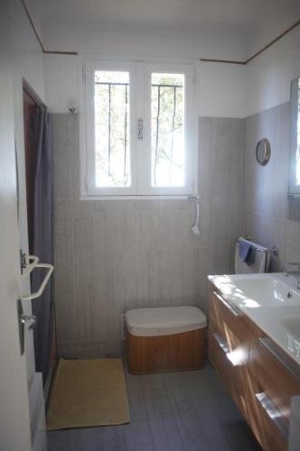 a bathroom with a toilet and a sink and a window at Les messugues aux issambres in La Garonnette-Plage