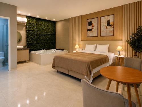 a bedroom with a bed and a tub and a table at Exclusive Hotel in Campos Sales