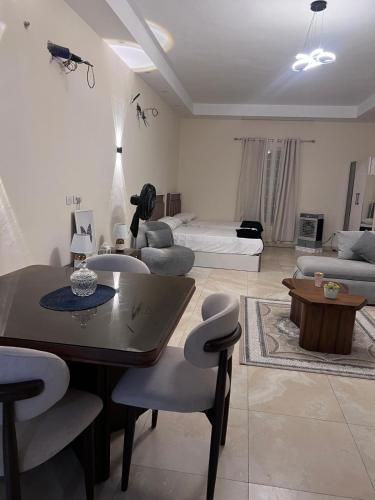 a living room with a table and chairs and a couch at New Alamein Latine district Spacious studio direct Lagon view in El Alamein