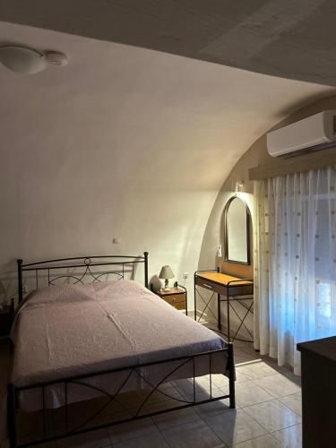 a bedroom with a bed and a table with a mirror at Matina's cozy home close to Monemvasia in Áyios Sarándos