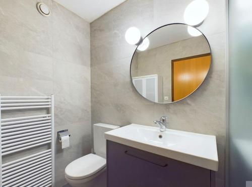 a bathroom with a sink and a mirror at Magnifique appartement avec vue sur les sommets enneigés in Crans-Montana