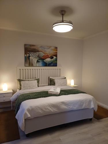 a bedroom with a bed and a painting on the wall at Cosy Stay in Robertson