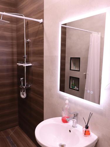 a bathroom with a sink and a mirror at AL-BUKHARI Boutique Hostel in Bukhara