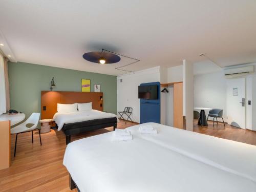 a hotel room with two beds and a tv at ibis Nürnberg Hauptbahnhof in Nuremberg