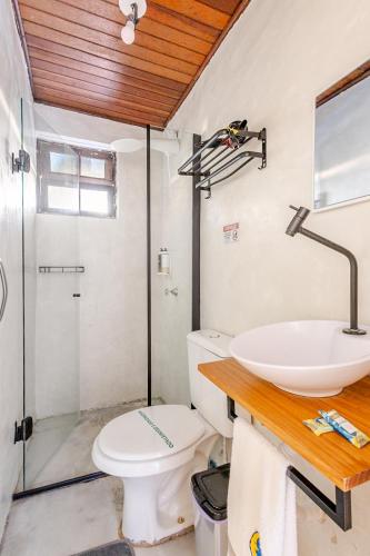 a bathroom with a toilet and a sink and a shower at Pousada Lua Chalés in Maresias
